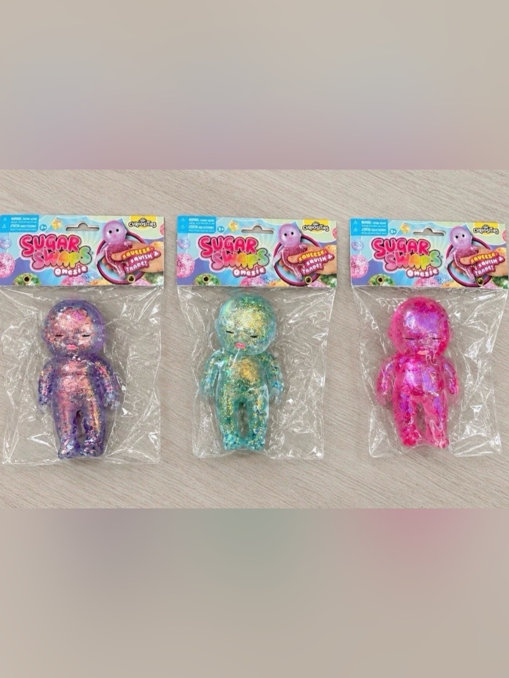 Lot Of 3 Sugar Swaps Baby Squishy Glitter Squeeze Toy 5” NEW Purple, Pink & Blue